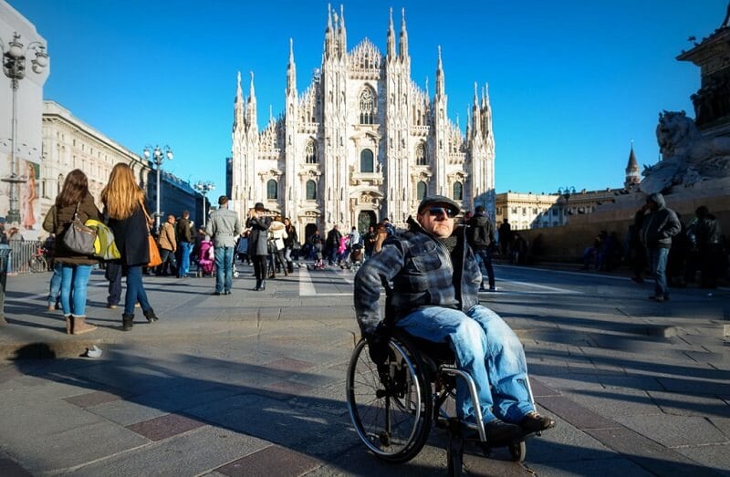 Cadeirante na Piazza del Duomo em Milão na Itália Cadeirante na Piazza del Duomo em Milão na Itália