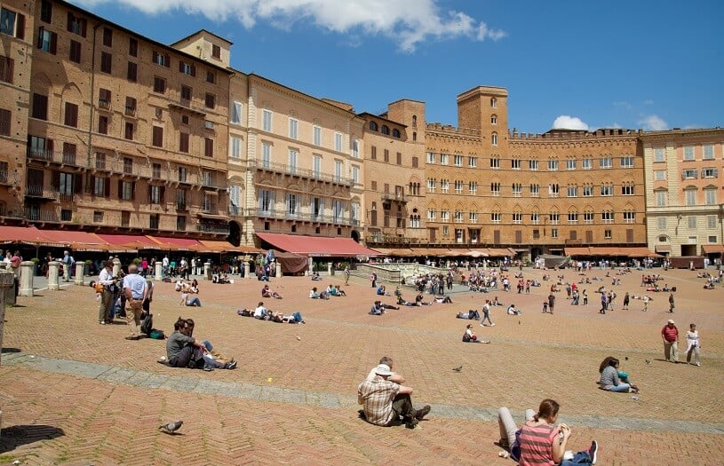 Pessoas sentadas na Piazza del Campo em Siena Pessoas sentadas na Piazza del Campo em Siena