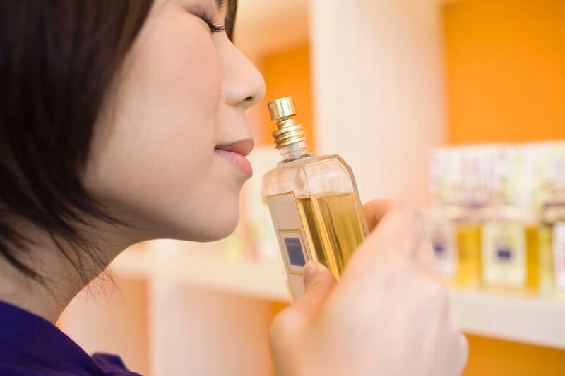Mulher sentindo aroma de perfume Mulher sentindo aroma de perfume